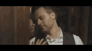 a man in a suit and tie is kissing a woman on the cheek .