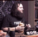 a man with a beard wearing a black shirt that says power on it