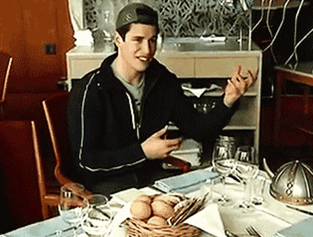a man sitting at a table with a basket of eggs