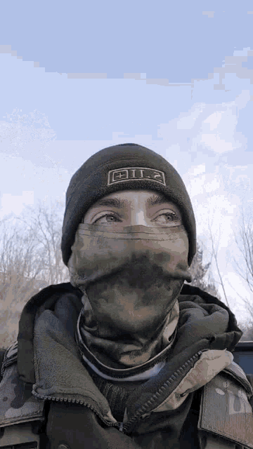 a man wearing a mask and a beanie with the letters 5.11 on it