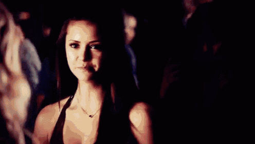 a woman with long dark hair is looking at another woman with a serious look on her face .