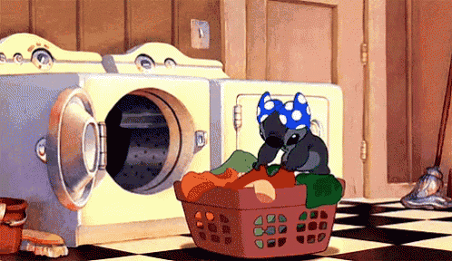 a cartoon of stitch sitting in a laundry room next to a washer and dryer