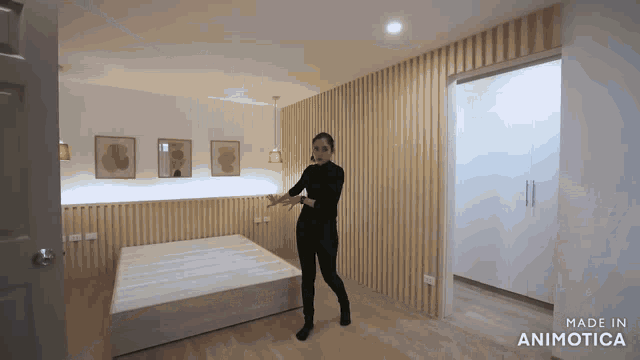 a woman is standing in a bedroom with the words made in animatica on the bottom right