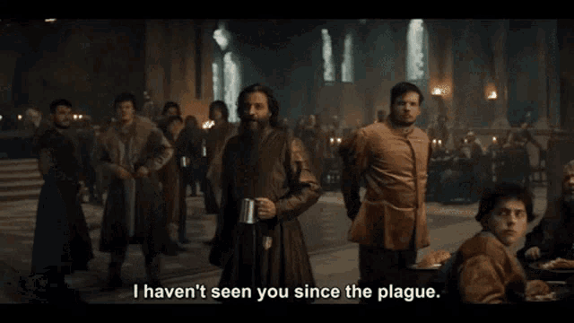 a man holding a beer mug in front of a crowd says i haven t seen you since the plague