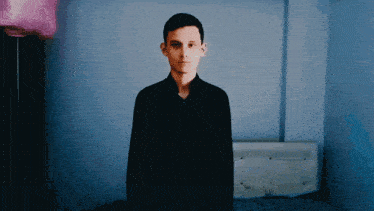 a man in a black shirt is standing in a room