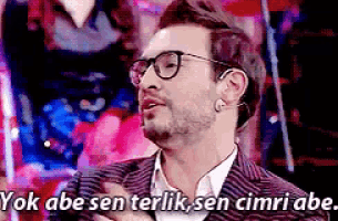 a man wearing glasses and a suit says yok abe sen terlik sen cimri abe ..