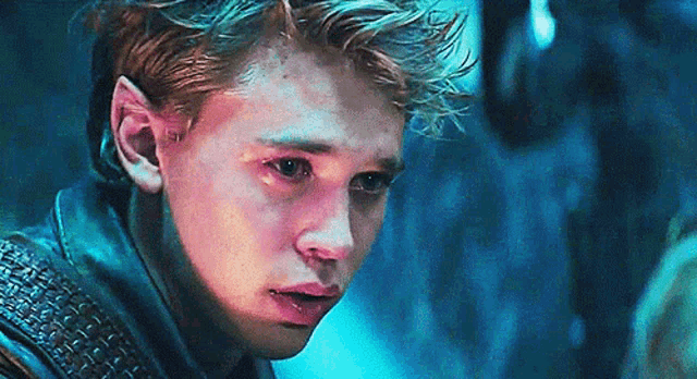 a close up of a young man 's face with a tear running down his face .