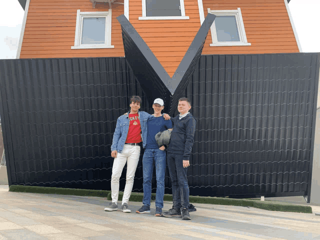 three young men stand in front of an upside down building