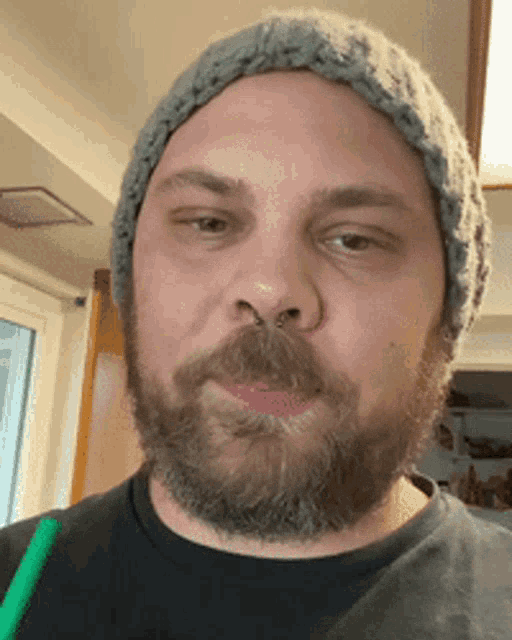 a man with a beard wearing a knitted hat