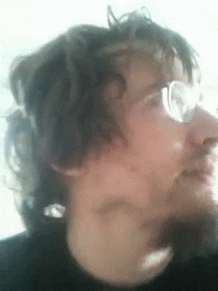a close up of a man 's face with glasses