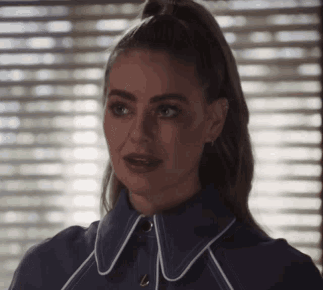 a woman with a ponytail is wearing a purple shirt