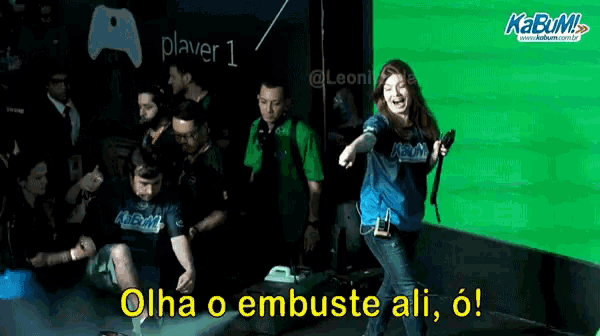 a group of people are standing in front of a green screen that says player 1 on it