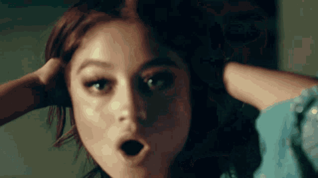a close up of a woman making a funny face with her mouth open .