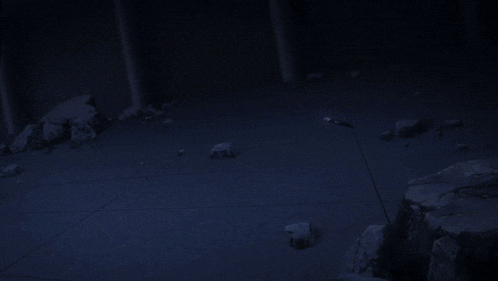 a person is holding a sword in their hand in a dark room