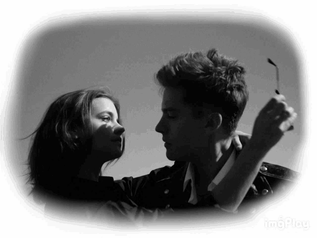 a black and white photo of a man and a woman looking into each other 's eyes with the words imgplay below them