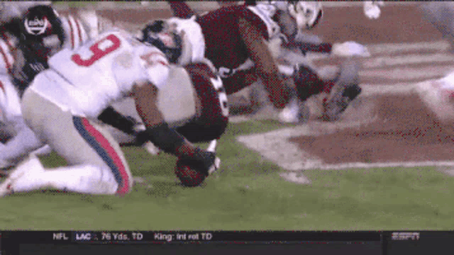 a football player with the number 9 on his jersey is being tackled by another player