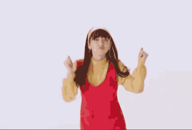 a woman in a red dress and yellow top is dancing