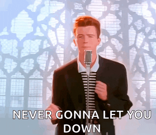a man in a suit singing into a microphone with the words never gonna let you down below him