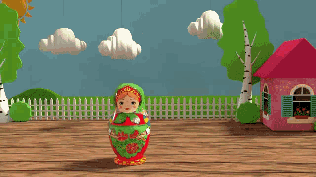 two russian nesting dolls are on a wooden table in front of a pink house