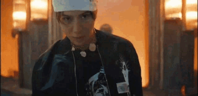 a close up of a person wearing a headband and a jacket .