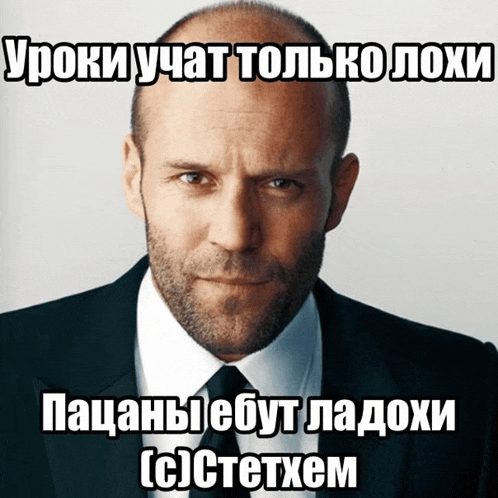 a man in a suit and tie looks at the camera with a caption in russian