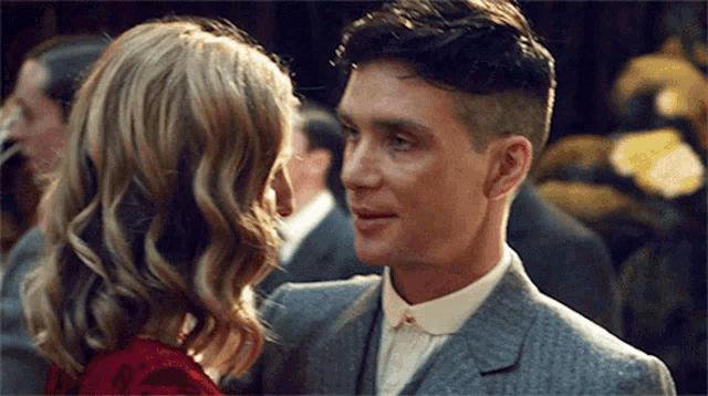 a man and a woman are dancing together in a crowded room .