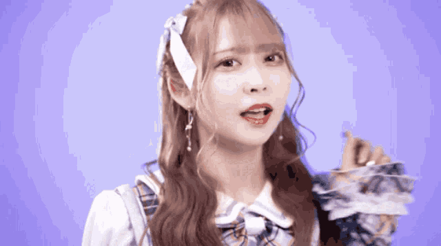a girl with a bow in her hair is making a funny face with her mouth open