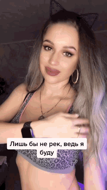 a woman wearing a cat ear headband and a leopard print bra has a caption in russian
