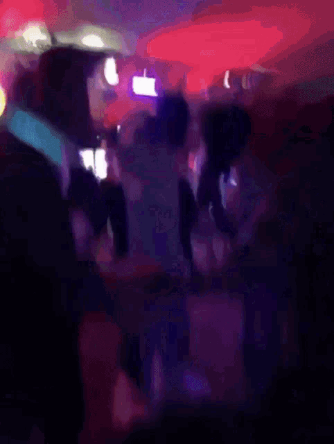 a group of people dancing in a dark room
