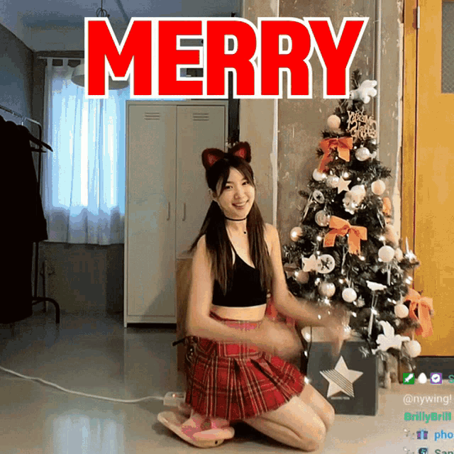 a girl in a plaid skirt is kneeling in front of a christmas tree with merry written in red