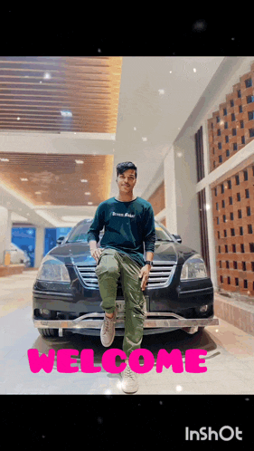 a man sitting in front of a car with the word welcome written on it
