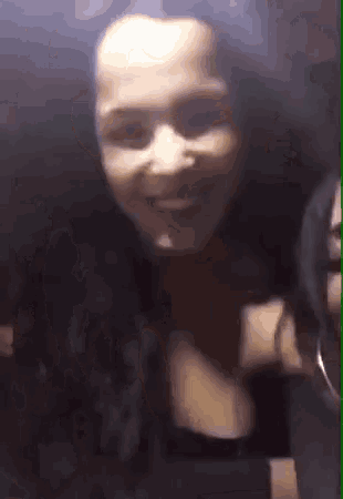 a close up of a woman 's face and neck in a dark room .