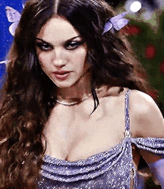 a woman in a purple dress with a butterfly in her hair