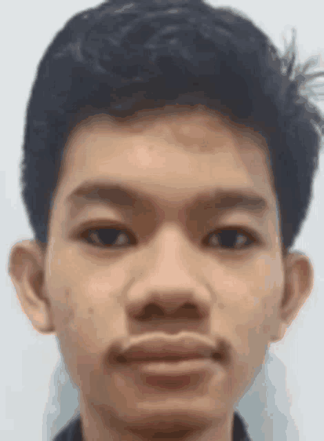 a close up of a young man 's face with a slight smile .