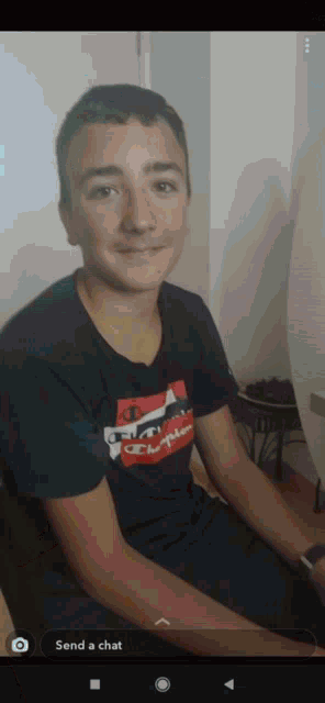 a young man wearing a champion t-shirt is smiling