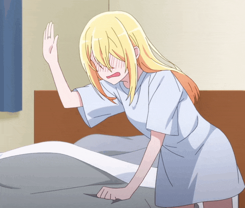a girl with blonde hair is standing next to a bed covering her face with her hand