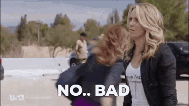 two women are standing next to each other in a parking lot and one of them is saying `` no ... bad '' .