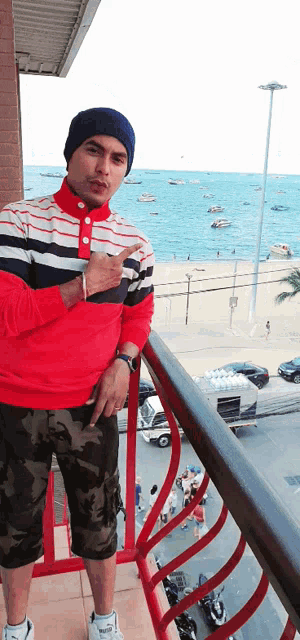 a man standing on a balcony pointing at the water