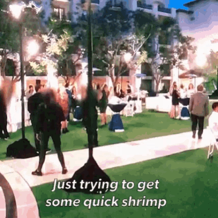 a group of people are standing in a grassy area with the caption just trying to get some quick shrimp .