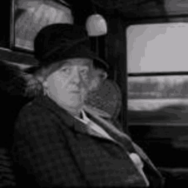a woman wearing a top hat is sitting in a car .
