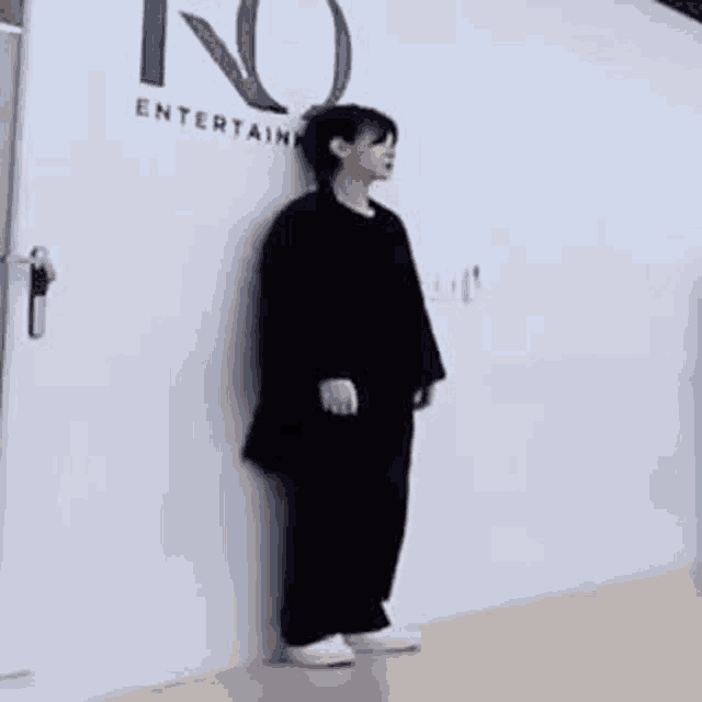 a person is leaning against a wall in a room .