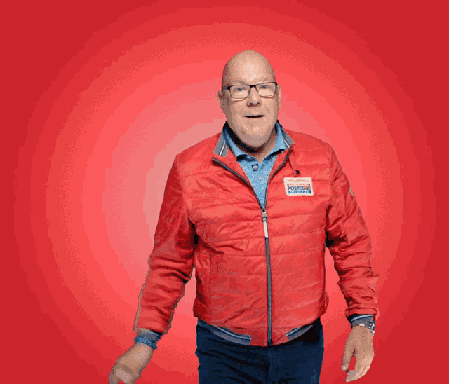 a man wearing a red jacket with a sticker that says ' camper motors '