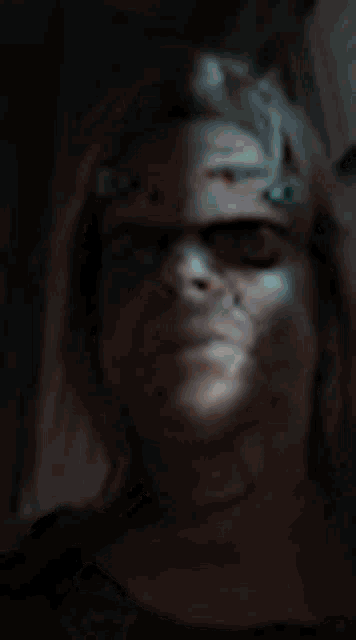 a blurry picture of a woman 's face with a light shining on it .