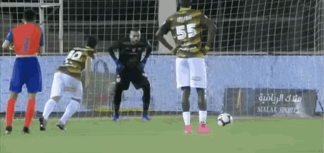 a soccer player with the number 55 on his back stands in front of a goal