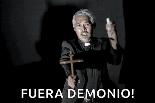 a man in a suit is holding a wooden cross and the words fuera demonio are above him