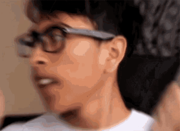 a man wearing glasses and a white shirt is making a funny face