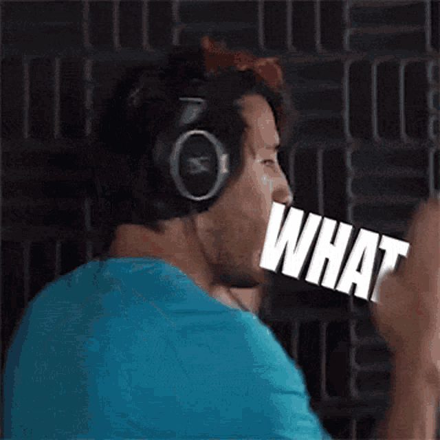 a man wearing headphones and a blue shirt has the word what in his mouth .