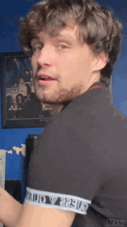 a man with a beard is wearing a black shirt with the word versus on the sleeves