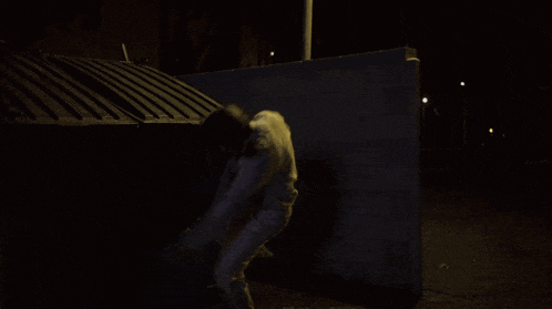 a shadow of a person is cast on a dark wall