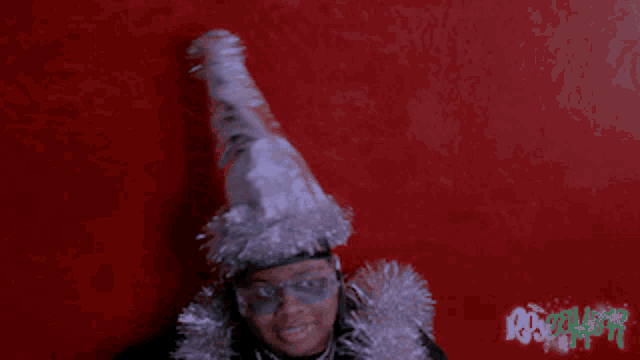 a man wearing a santa hat and sunglasses against a red background
